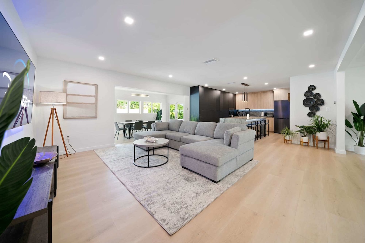 Open floor plan of Villa Paradiso with the sectional couch, 75 inch Smart TV and designer eat-in kitchen